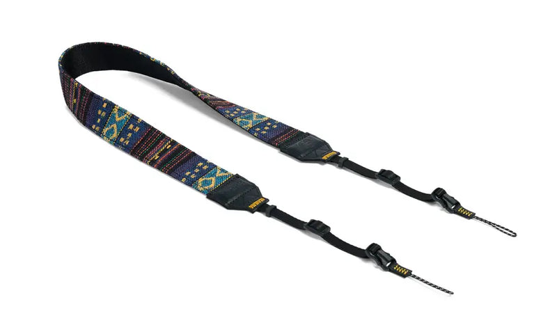Blue and yellow patterned camera strap with black leather accents and adjustable buckles