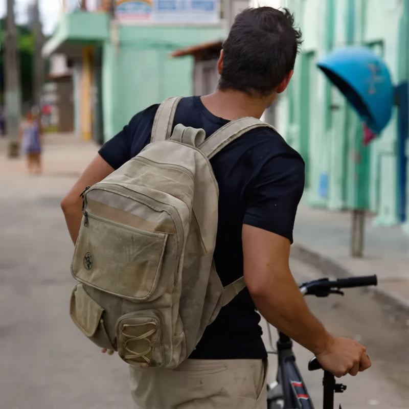 Man with a backpack and bicycle on a street