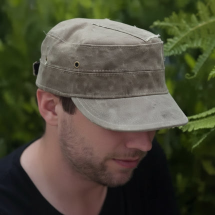 Man wearing a distressed olive green military style cap with a short brim