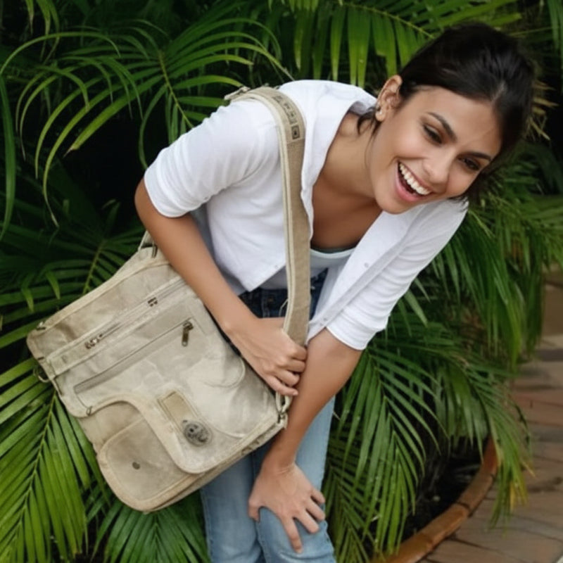 Woman in white shirt and jeans carrying a beige canvas messenger bag
