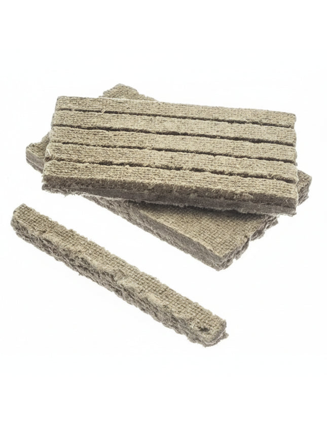 Several rectangular pieces of light brown, fibrous material with horizontal grooves, on a white background