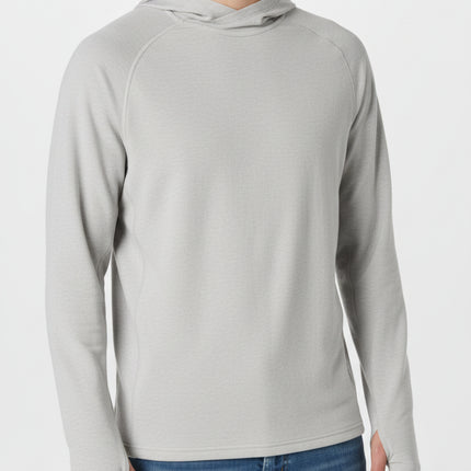 Man wearing a light grey long-sleeved hoodie with thumbholes