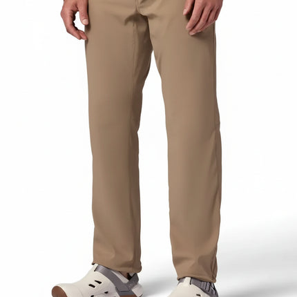 Man wearing tan pants and a long-sleeved brown shirt with white and gray slip-on shoes