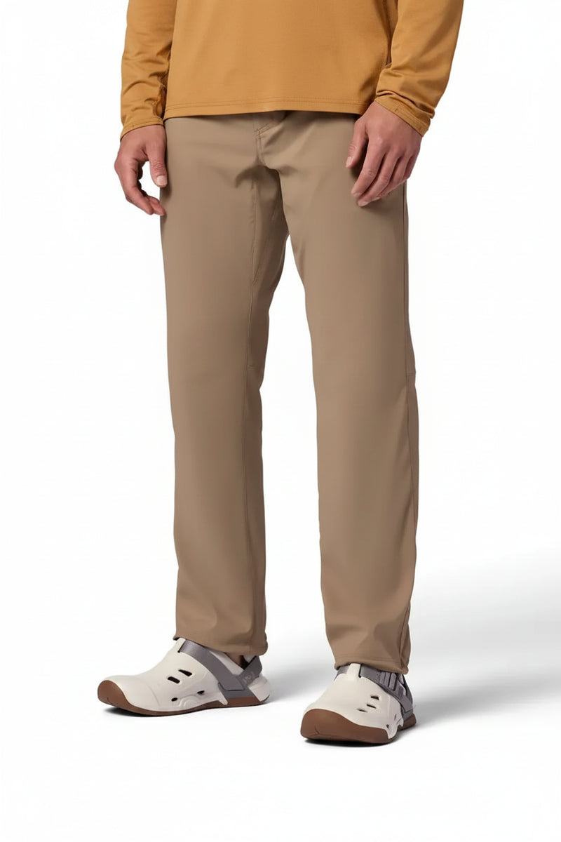 Man wearing tan pants and a long-sleeved brown shirt with white and gray slip-on shoes