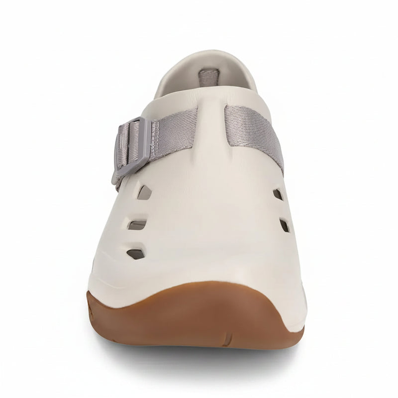 Front view of a cream-colored shoe with a brown sole and a gray strap across the top