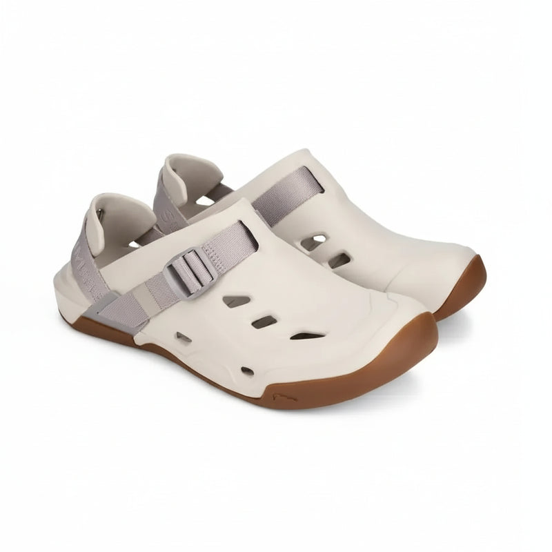 Pair of light beige closed-toe sandals with grey straps and brown soles