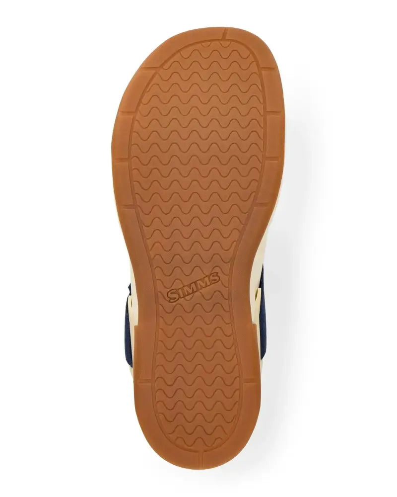 Underside of a sandal with a brown sole and the Simms logo