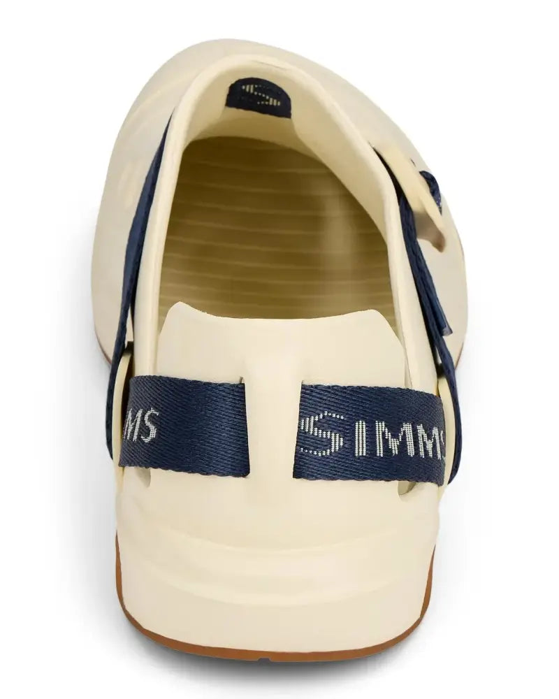Back view of a cream-colored fishing clog with a navy blue strap featuring the Simms logo