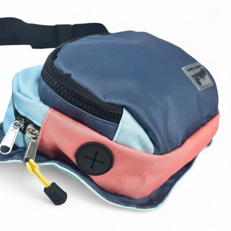 Close up of a blue, light blue, and pink fanny pack with a black zipper and a black button