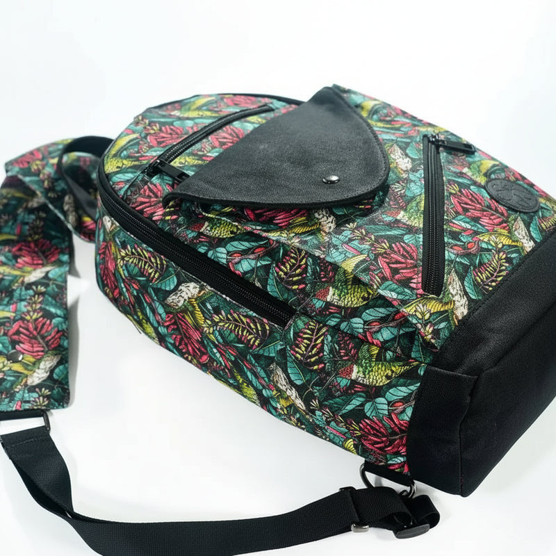 Tropical print backpack with black zippers and flap closure