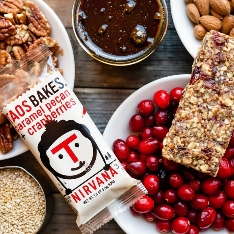 Taos Bakes Nirvana bar with caramel pecan and cranberries, surrounded by ingredients