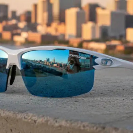White sunglasses with blue mirrored lenses reflecting a city skyline