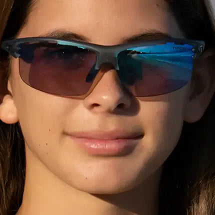 Young woman wearing dark sunglasses with blue reflective lenses