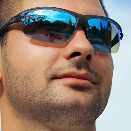 Man wearing black half-rim sunglasses with blue mirrored lenses