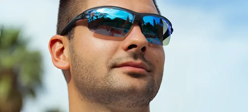 Man wearing black half-rim sunglasses with blue mirrored lenses
