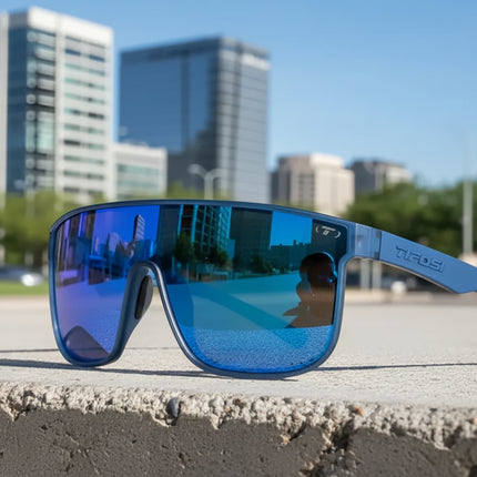 Tifosi blue sunglasses with reflective lenses on a concrete ledge