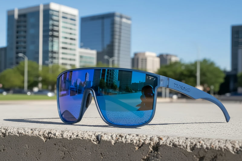 Tifosi blue sunglasses with reflective lenses on a concrete ledge