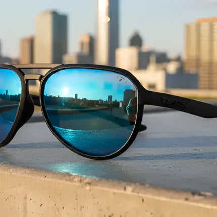 Black sunglasses with blue mirrored lenses reflecting a city skyline