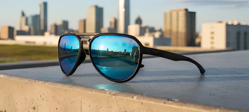 Black sunglasses with blue mirrored lenses reflecting a city skyline