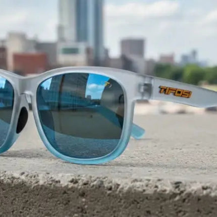 Tifosi sunglasses with blue lenses on a concrete ledge