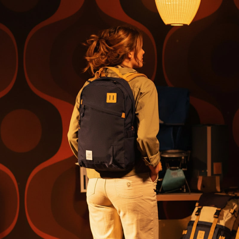 Woman wearing a black backpack with a yellow logo and straps