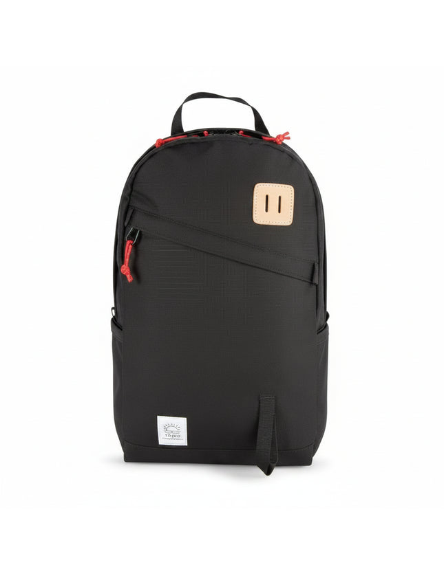 Black backpack with red zipper pulls and a light brown leather patch on the front