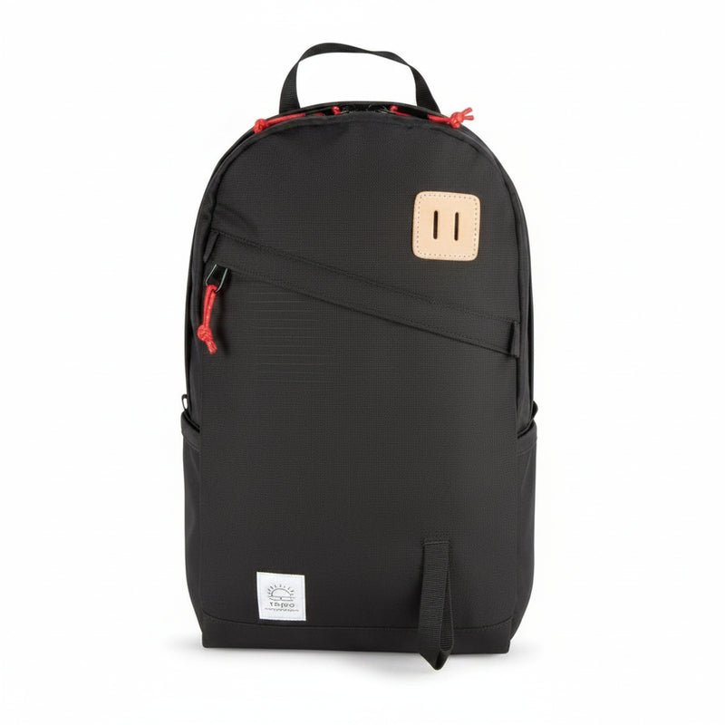 Black backpack with red zipper pulls and a light brown leather patch on the front