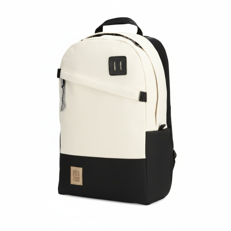 Two-tone backpack in cream and black with a front zipper pocket and a small brand patch
