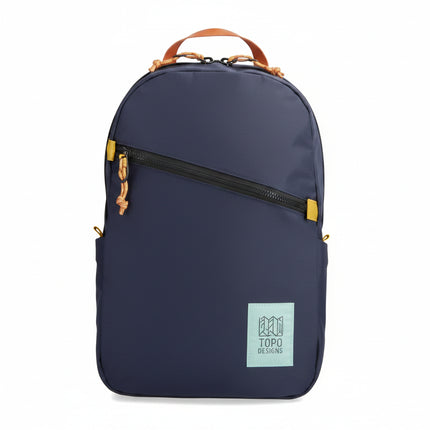 Navy backpack with a diagonal black zipper and a light blue Topo Designs logo patch