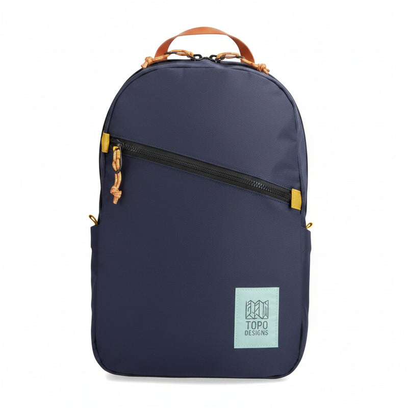 Navy backpack with a diagonal black zipper and a light blue Topo Designs logo patch