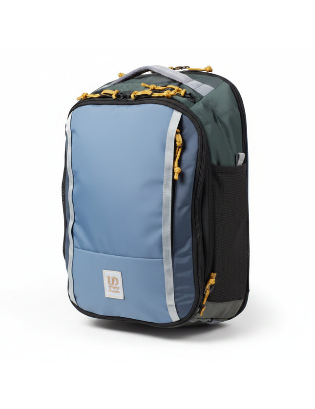 Blue and green backpack with yellow zipper pulls and a small square logo on the front