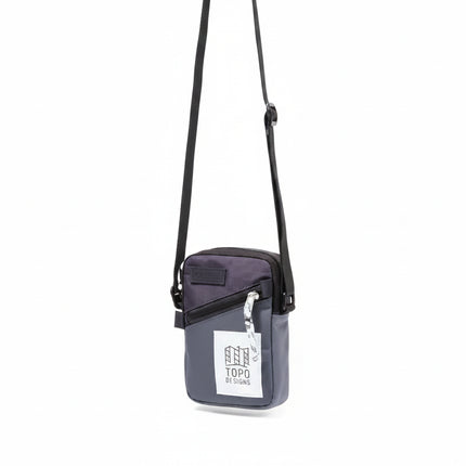 Topo Designs Global Shoulder Bag in charcoal and black with a white tag