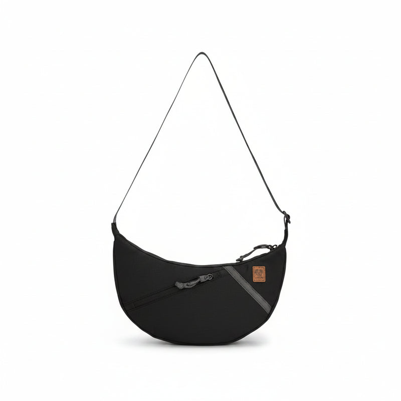 Black crescent-shaped shoulder bag with a single strap and a small brown tag