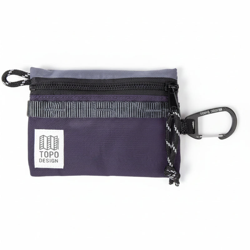 Topo Designs purple accessory bag with a black zipper and a carabiner clip