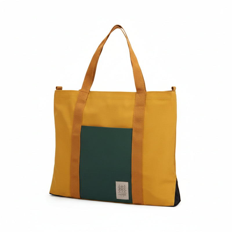 Mustard yellow tote bag with a dark green front pocket and brown straps