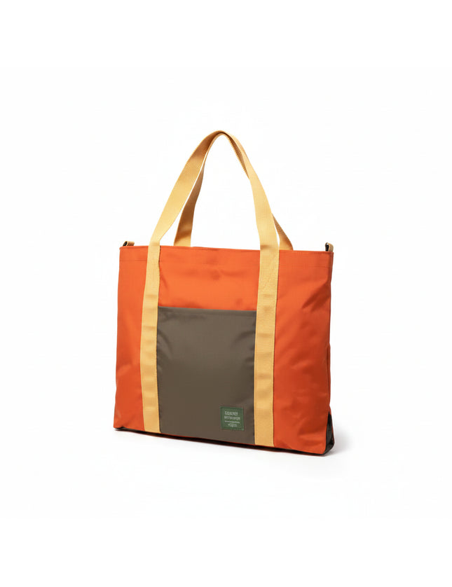 Orange tote bag with a dark grey front pocket and tan straps