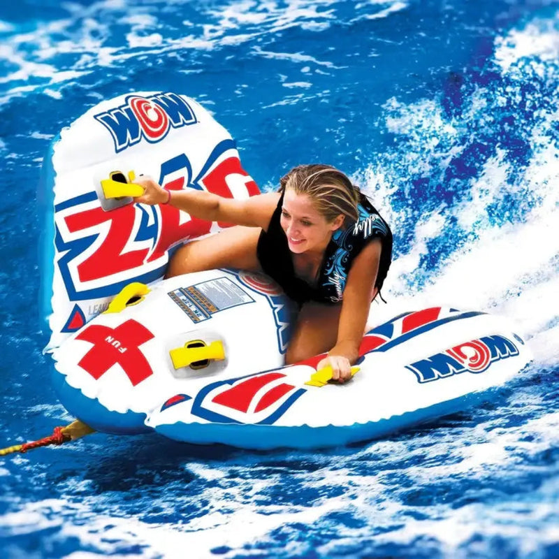 Woman on a white and blue inflatable tube with red accents, riding on blue water