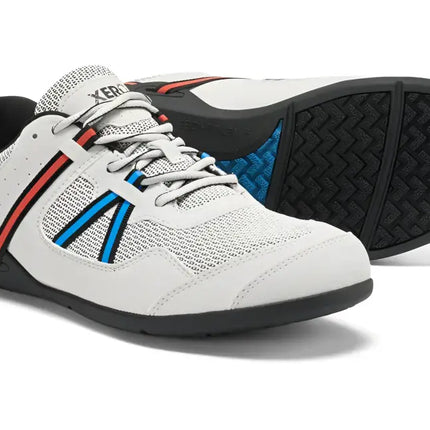 White Xero Shoes with red and blue stripes on the side, black soles, and a black pull tab