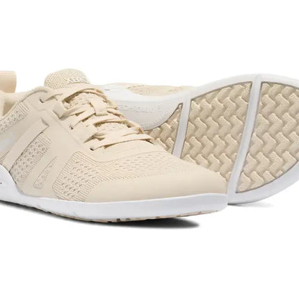 Pair of light beige athletic shoes with white soles, one shoe upright and the other on its side showing the sole