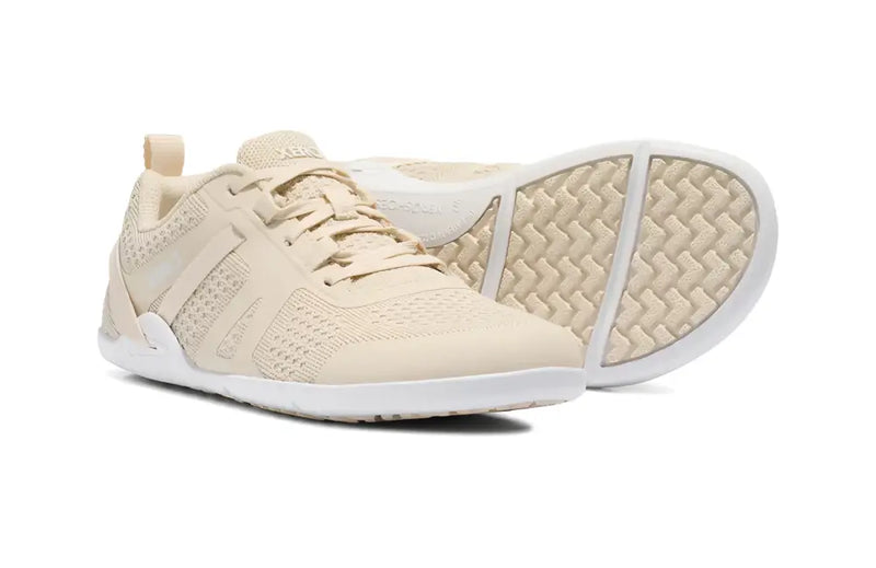 Pair of light beige athletic shoes with white soles, one shoe upright and the other on its side showing the sole